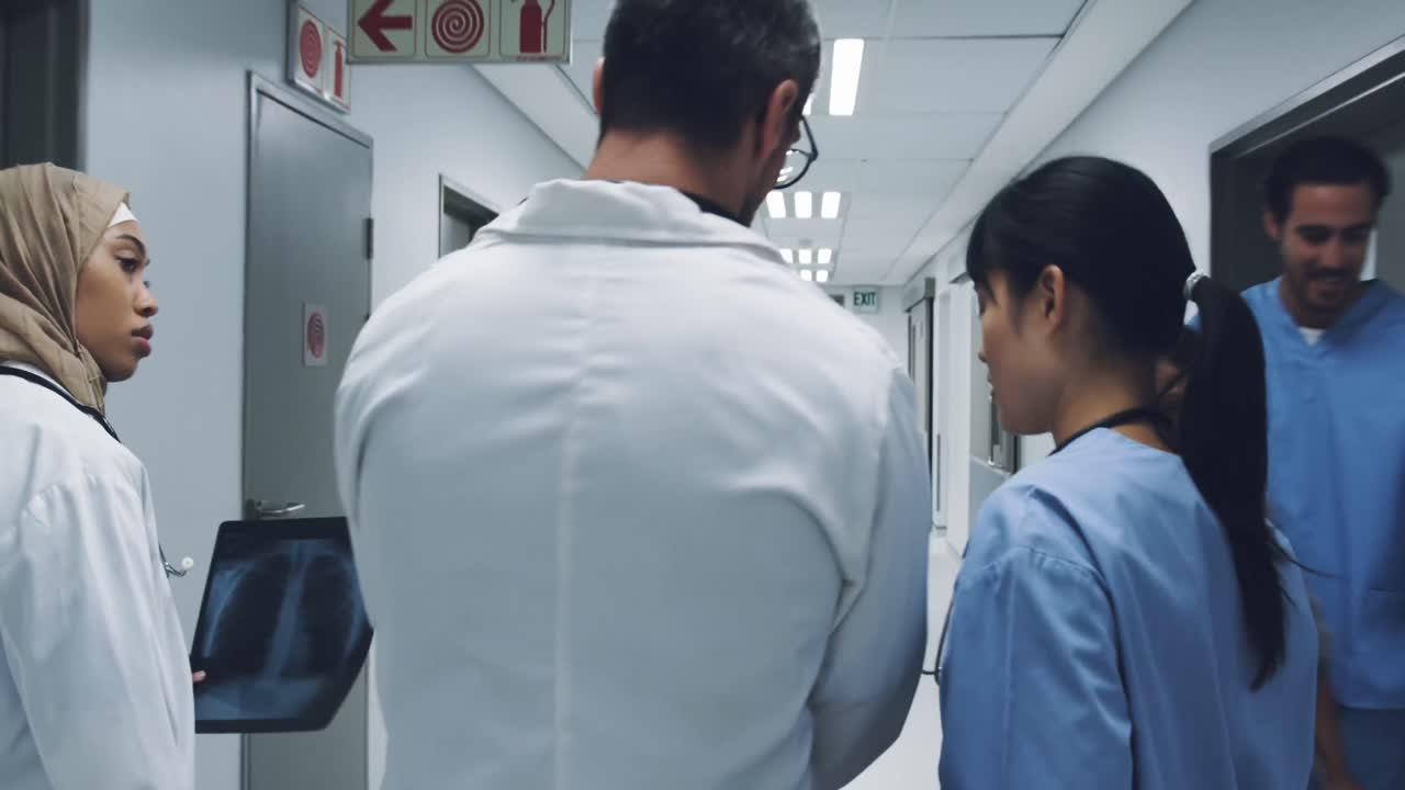 Back view of three doctors walking in hospital corridor 4k