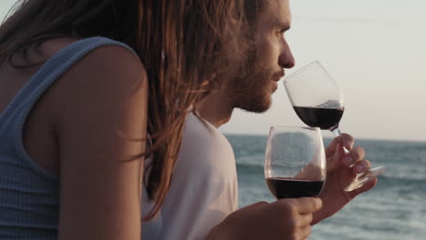 couple drinking wine on sea shore