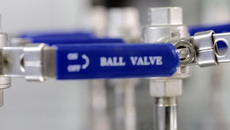 tracking shot of blue valves inside a science lab