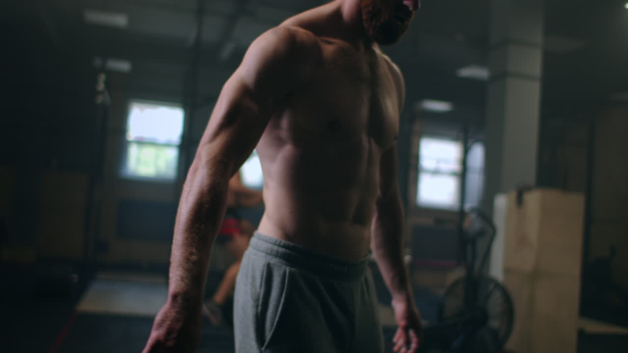 un bodybuilder maschile sta flettendo le braccia e si sta preparando per un allenamento in palestra.