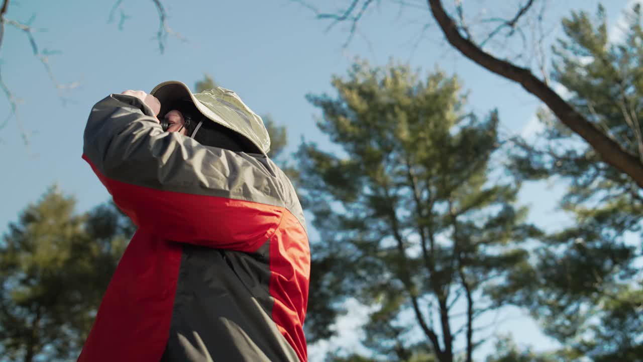 자연 속에서 사진을 찍고 쌍안경으로 바라보는 남자