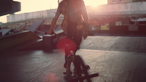 sporty man making dangerous trick on bmx bike at skate park. rider practicing.