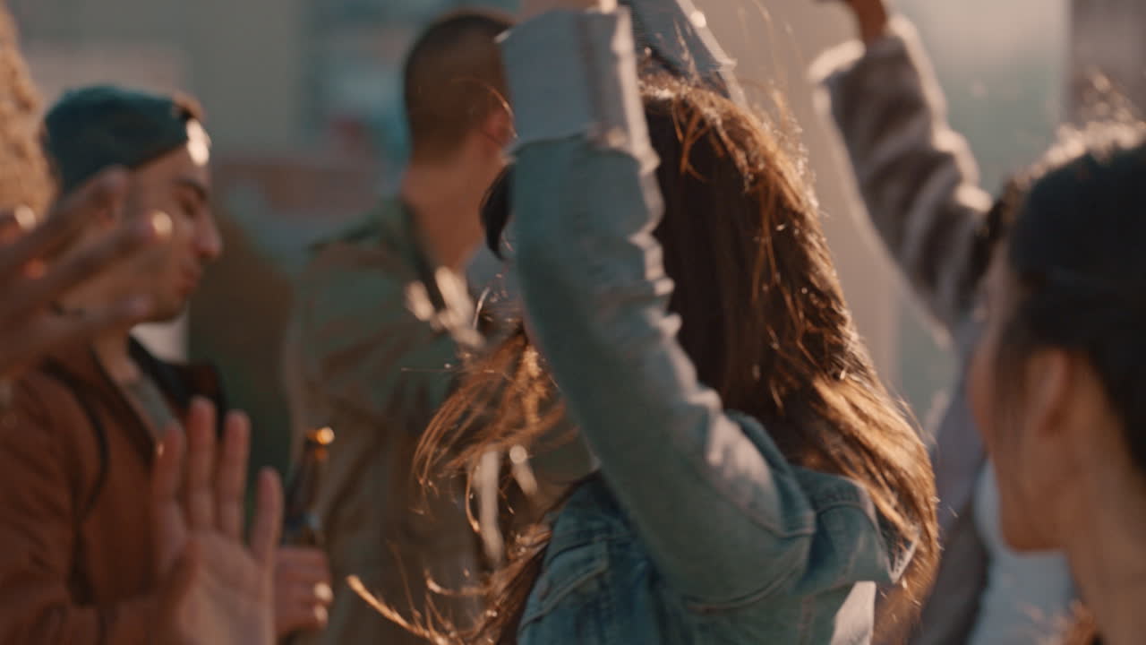 grupo de amigos multirraciales en cámara lenta pasando el rato joven mujer asiática bailando disfrutando de una fiesta en la azotea al atardecer bebiendo alcohol divirtiéndose en la celebración del fin de semana