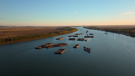 aerial tracking wide shot of anchored barges on a big blue river, clear sunny day, 4k50fps