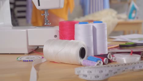 sewing machine and sewing supplies on the table in the studio of a fashion designer,nobody close up