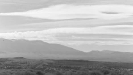 rocky mountains on the horizon in a desert landscape on a summer day of 1930s