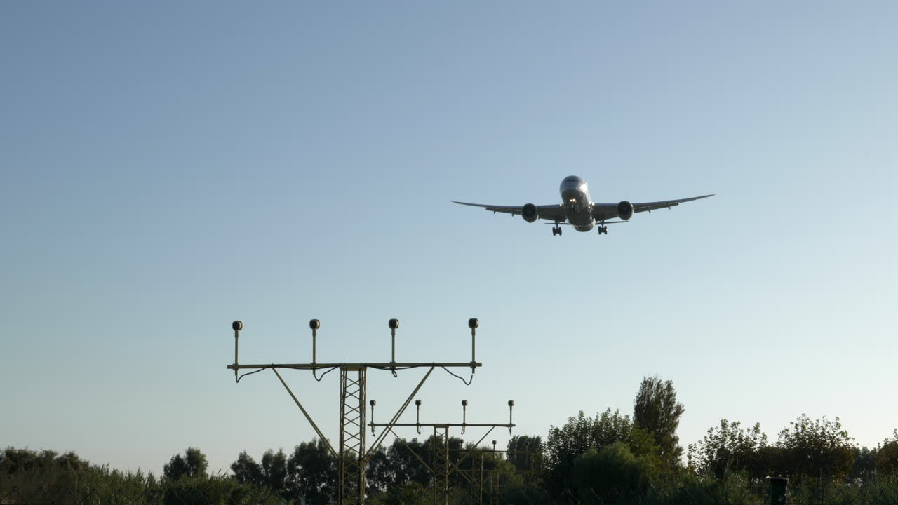 un gran avión comercial acercándose a la pista de aterrizaje sobre el área forestal