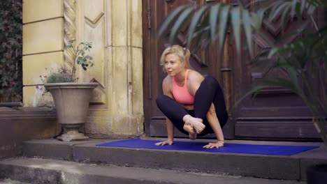 Woman-doing-difficult-yoga-asana-balancing-on-hands-outdoors