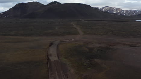 Birds-eye-4x4-car-driving-offroad-in-Iceland-.-Aerial-view-of-Skaftafell-national-park-majestic-moonscape-of-green-moss-highlands-and-snowy-high-mountains-peak.-Amazing-in-nature