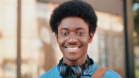 close-up view of african american man looking and smiling at camera in the street