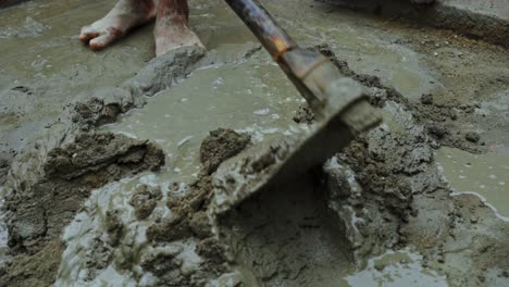 mezcla de cemento en un remoto pueblo indio sitio de construcción trabajo descalzo cerca de condiciones de trabajo inseguras concepto