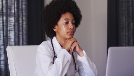 Afroamerikanische-Ärztin-Führt-Einen-Videoanruf-Auf-Dem-Laptop,-Während-Sie-Zu-Hause-Sitzt