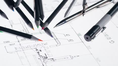 colored pencils and drafting tools on technical blueprint