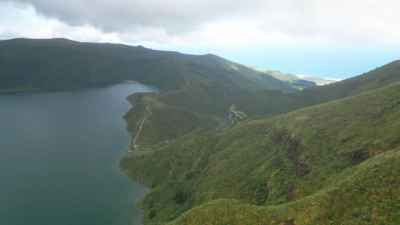 exuberantes colinas verdes rodean un lago sereno bajo un cielo nublado en lagoa do fogo, azores