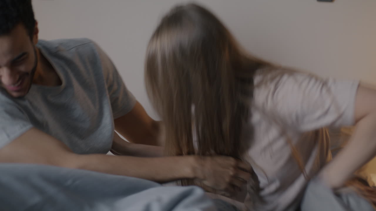 una pareja divirtiéndose en la cama.