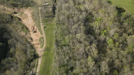 aerial flyover construction site and deforestation with digger in green woodland