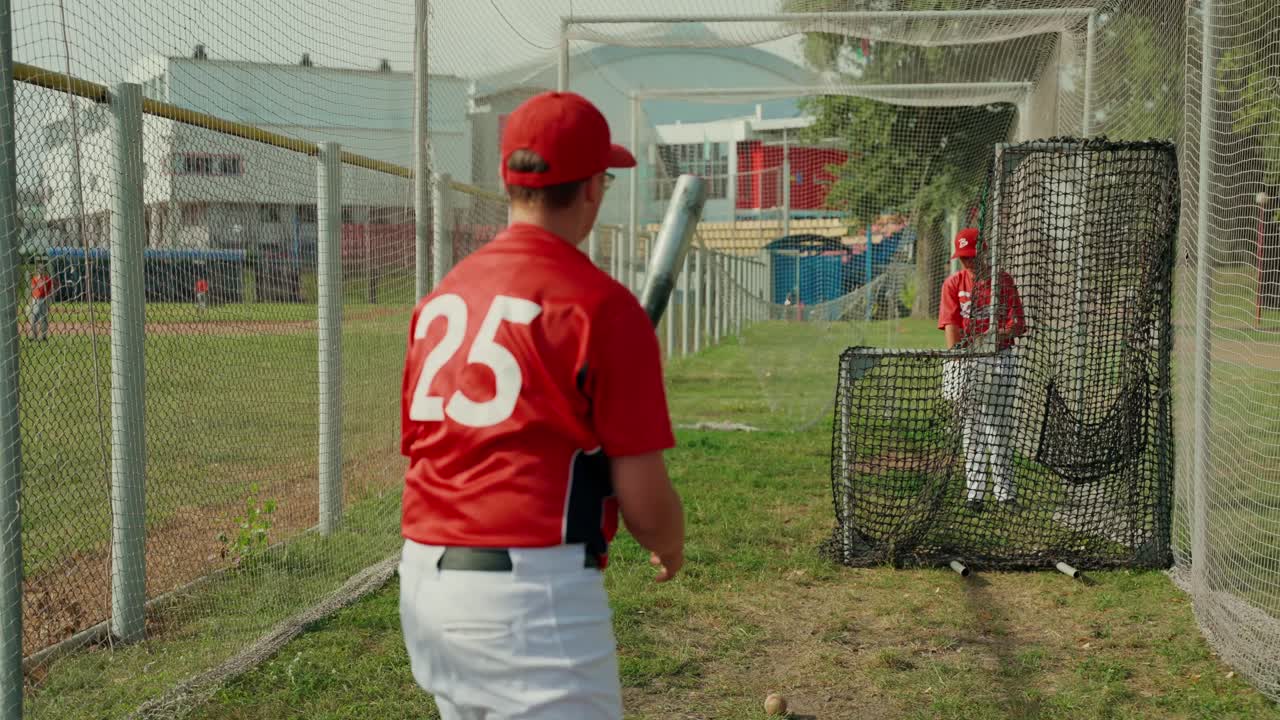 Giocatori di baseball che si allenano in una gabbia di battuta
