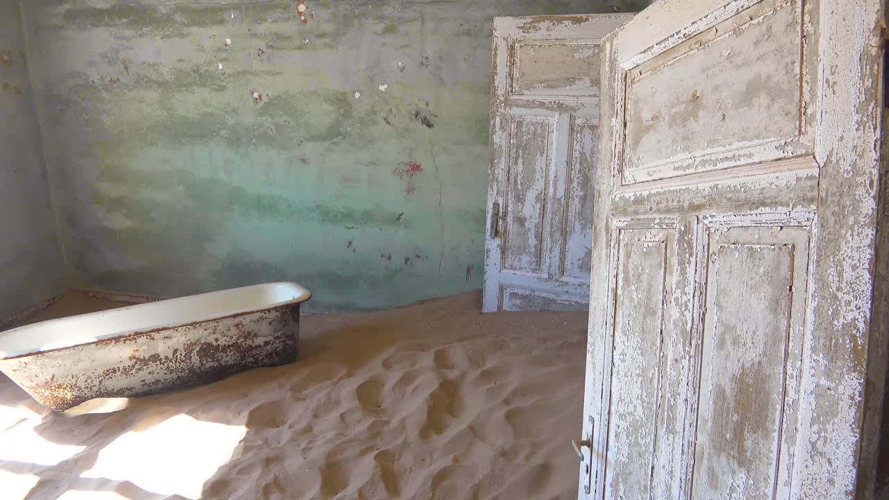 arena y una bañera llena un edificio abandonado en la ciudad fantasma de minería de gemas de kolmanskop namibia 1