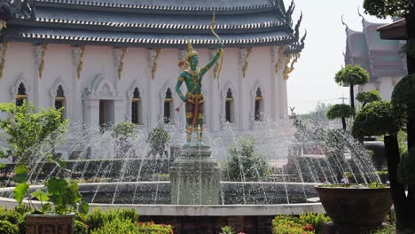 thai temple garden with fountain and statue