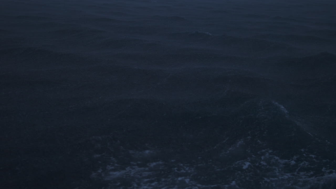 Gloomy ocean backdrop with uneven storm swells rolling through misty rain