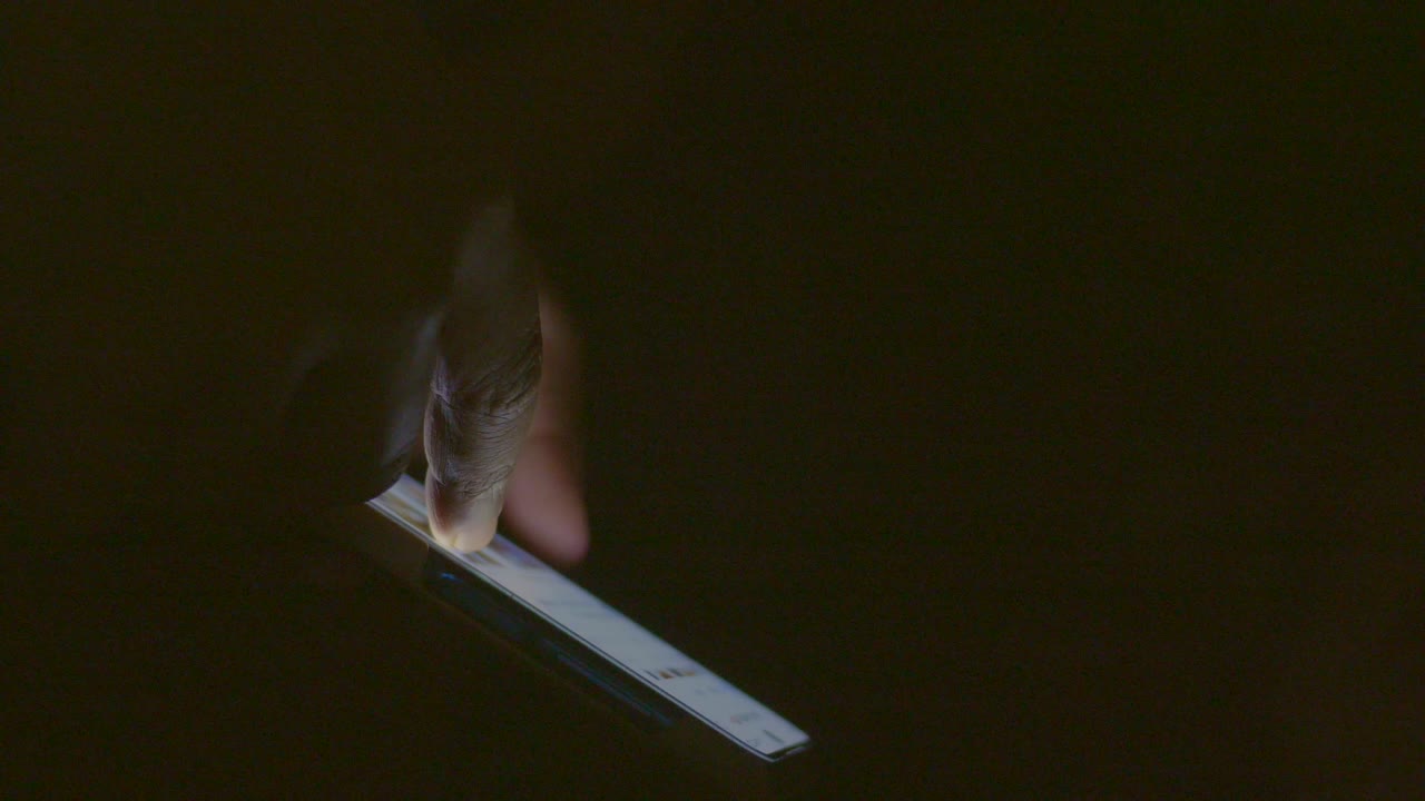 persona que utiliza un teléfono inteligente en la oscuridad