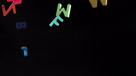 colorful letters falling on black background