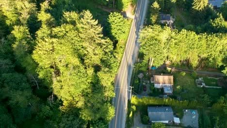 drone shot over small town with houses , roads, lake and mountains