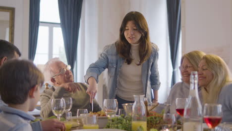 young girl mixing paella dish and enjoying a holiday dinner with her family at home