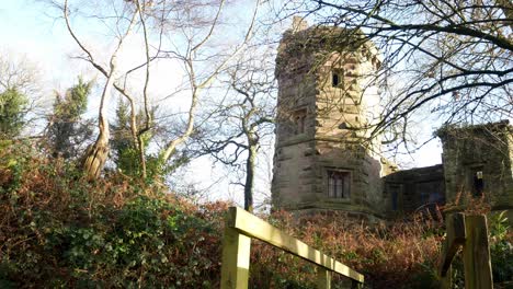 abandoned autumn woodland watchtower stone castle keep building in rural english countryside low right dolly