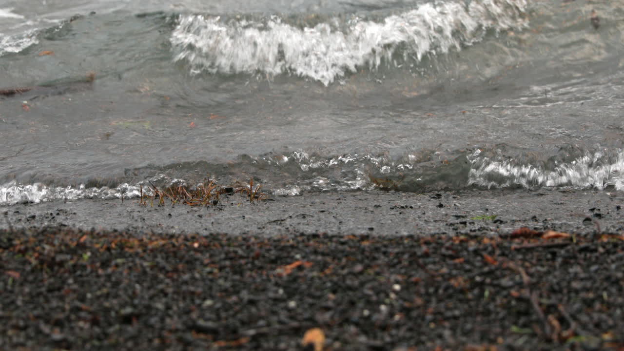 미국 워싱턴 주 초승달 호수에 있는 바위 해안에 파도가 튀고 있습니다.