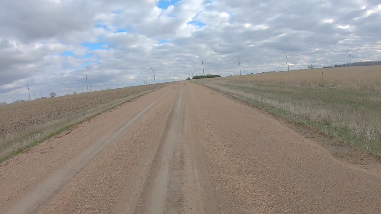 흐린 겨울날 시골 네브래스카를 통해 자갈길에서 커브를 돌면서 뒷창 보기