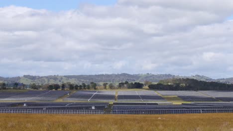 expansive solar panel field under cloudy sky