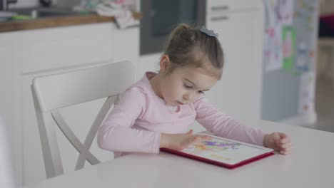 chica enfocada jugando en la tableta