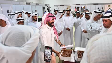 uae date festival: men examining and buying dates