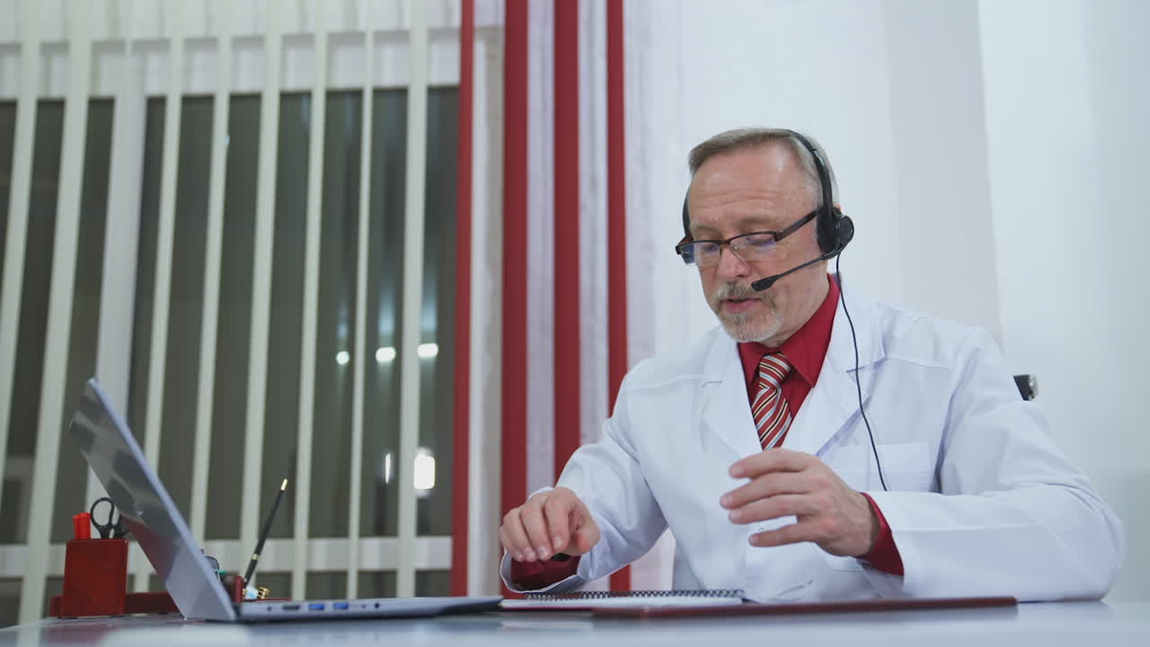 Concetto di telemedicina. Medico uomo con cuffie che parla con il paziente tramite webcam.
