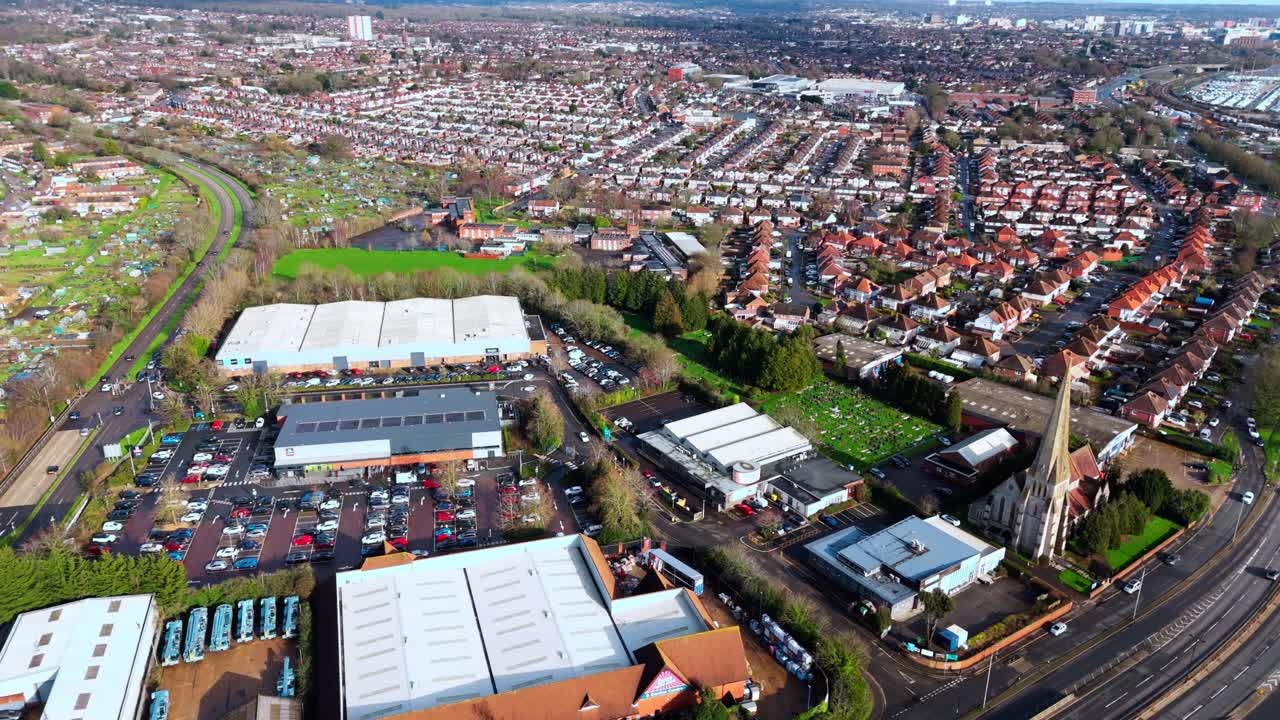 Luchtopname met drone vanuit een hoge hoek boven de voorstedelijke woonwijk Millbrook in Southampton bij zonsondergang, omringd door bomen, huizen en natuur. Opgenomen in de winter met verkeer en auto's op straat