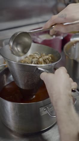 chef straining ingredients in a commercial kitchen