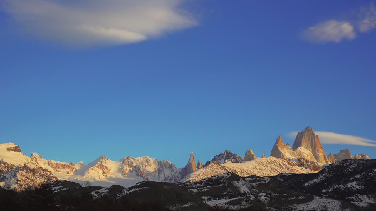 Timelapse con luce mattutina della catena montuosa del Fitz Roy dalla città di El Chalten, che evidenzia le cime di granito sotto un cielo sereno. Parco Nazionale Los Glaciares, Patagonia, Argentina