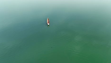 Aerial-view-of-a-man-in-a-canoe-on-a-lake-in-Abuja,-Nigeria