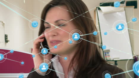 animación de una red de iconos digitales sobre una mujer de negocios caucásica hablando en su teléfono inteligente en la oficina.