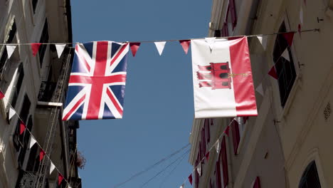 Banderas-De-Gran-Bretaña-Y-Gibraltar-Colgando-De-Una-Cuerda-Entre-Casas