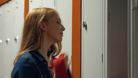 student gathering her school books from a locker