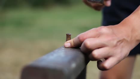 blacksmith hammering a bullet on anvil, metalsmith workshop, close up