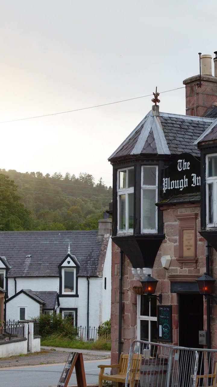 Kameraet panorerer forbi traditionelle bygninger og pubben The Plough Inn i skumringen i landsbyen Rosemarkie.