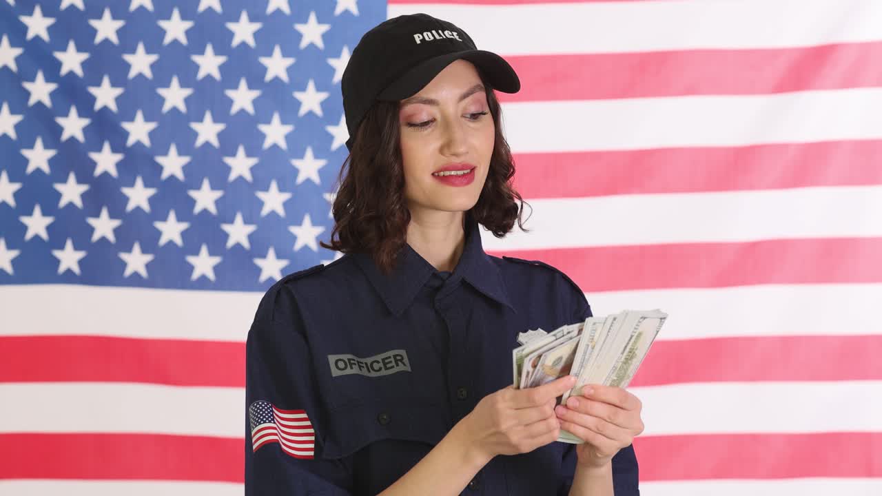 Woman police officer counts seized cash in front of usa flag