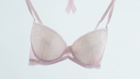 animation of bra and ribbon hanging on wire on white background