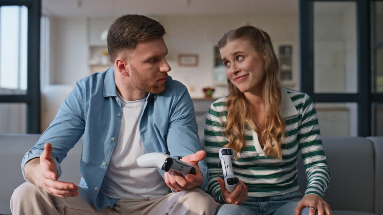 Young couple competing online sitting sofa at home closeup. Woman winning game