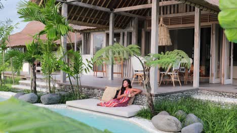 slow-motion-of-asian-woman-relaxing-poolside-at-a-bohemian-luxury-villa-in-bali-on-overcast-day