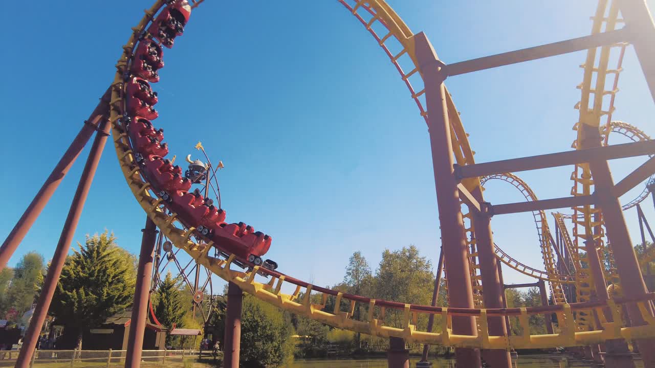 following roller coaster cart making 3 loopings in theme parc asterix sunny day