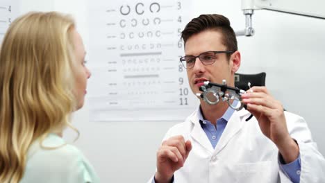 optometrista discutiendo sobre el espejo con una paciente femenina
